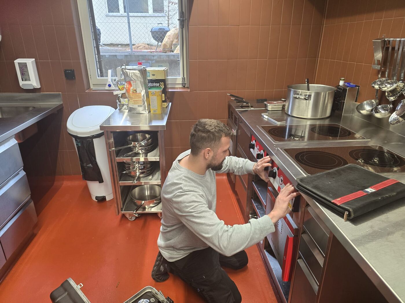 Techniker kontrolliert die Drehschalter einer Herdanlage